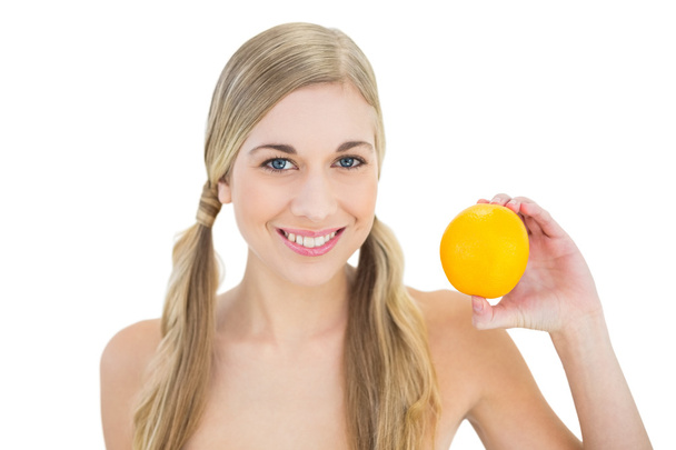 Content young blonde woman holding an orange - Foto, Imagem