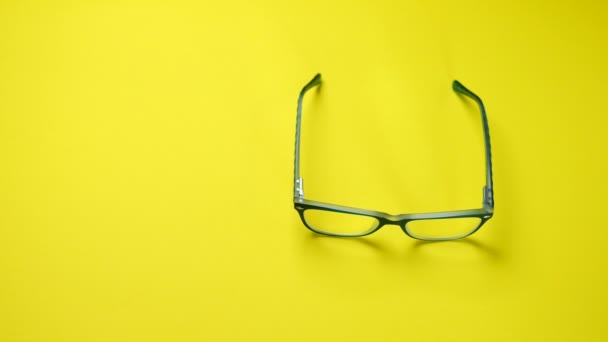 Αναζήτηση, εύρεση και λήψη γυαλιών σε μπλε πλαστικό πλαίσιο. Σε κίτρινο φόντο. - Πλάνα, βίντεο