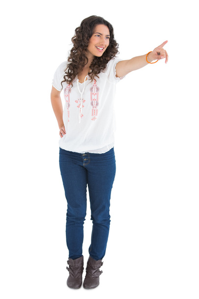 Cheerful attractive brunette wearing casual clothes pointing - 写真・画像