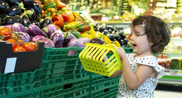 Child shopping eggplants in supermarket. Concept for buying frui - Photo, Image