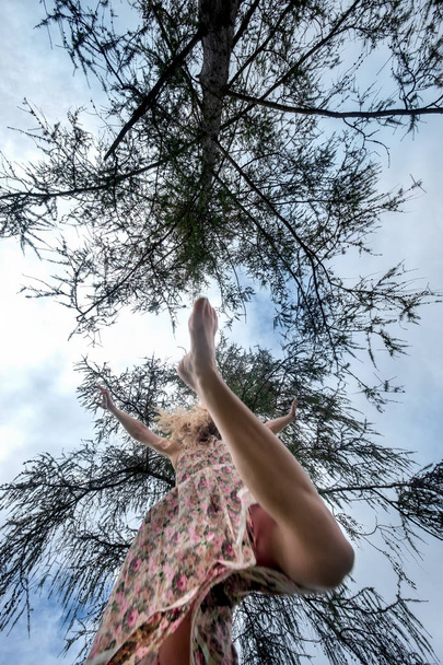 美しい女性が木の下を走りベルからの眺め - 写真・画像