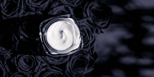 Gezicht crème huid moisturizer en zwarte rozen bloemen, luxe huid - Foto, afbeelding