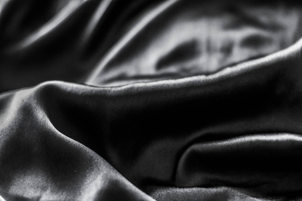 Luxe zwarte zachte zijde flatlay achtergrond textuur, vakantie glamo - Foto, afbeelding