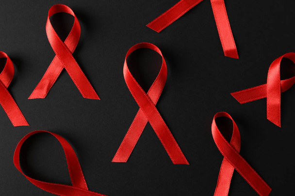 Awareness red ribbons on black background, close up - Foto, Imagen