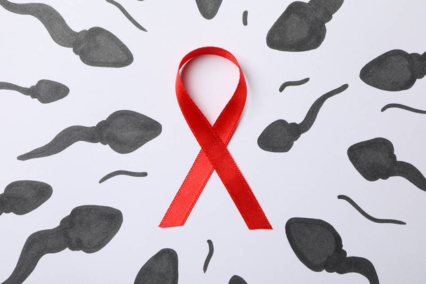 Red awareness ribbon and sperm cells on white background, close  - Photo, Image