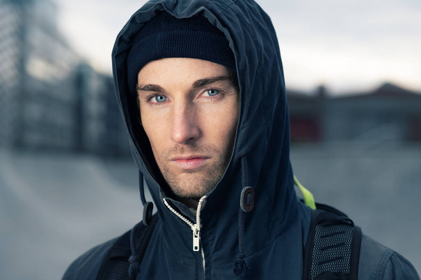 Portrait of a young attractive man wearing a hooded jacket - 写真・画像