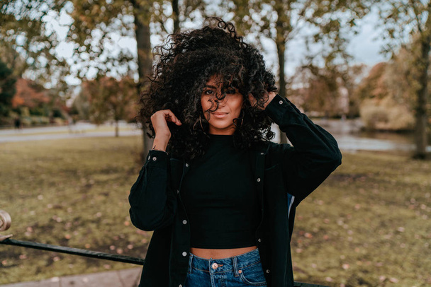 Portrait Charming Young African Woman with Curly Hair, Street Style - 写真・画像