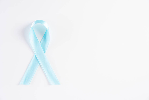 Голубая лента на белом фоне, представляющая собой ежегодное мероприятие в ноябре месяце для повышения осведомленности о мужских проблем со здоровьем и рака предстательной железы с копировальным местом
. - Фото, изображение