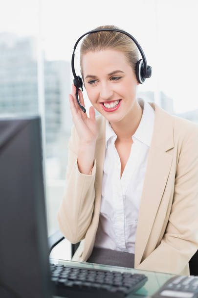 Smiling pretty agent wearing headset dealing with customer - Fotó, kép