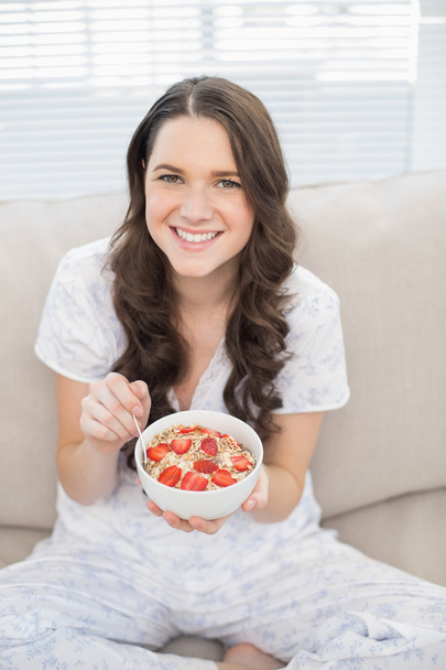 Smiling pretty woman in pyjamas eating fruity cereal - Foto, Imagem