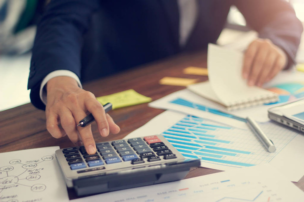 Podnikatel pomocí kalkulačky pro výpočet rozpočtu a analýzu prodejních dat a růstového grafu, Platby, Obchodní financování a účetnictví - Fotografie, Obrázek