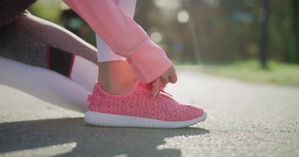 Ręczny widok kobiet ręce wiążące jej buty sportowe - Materiał filmowy, wideo
