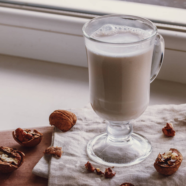 Walnut milk on a beige background, alternative drink, close-up - Foto, Imagem
