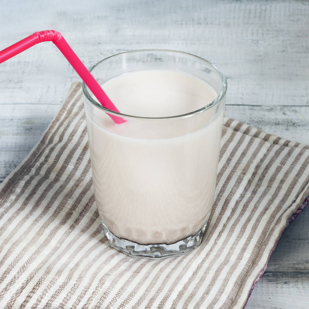 Sesame seed milk in a glass. White sesame seeds on a table. Raw food diet. - Photo, Image