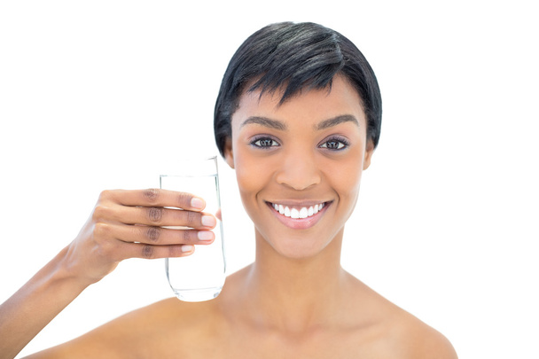 Cheerful black haired woman holding a glass of water - Photo, Image