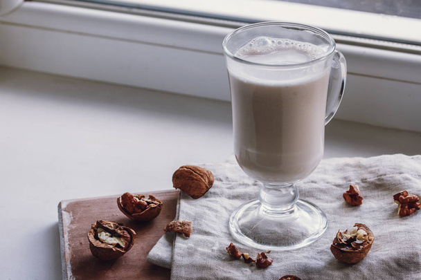 Walnut milk on a beige background, alternative drink, close-up - Foto, Imagem