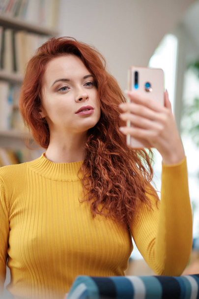 Woman taking a selfie with a smoothie using a mobile phone for h - Foto, imagen