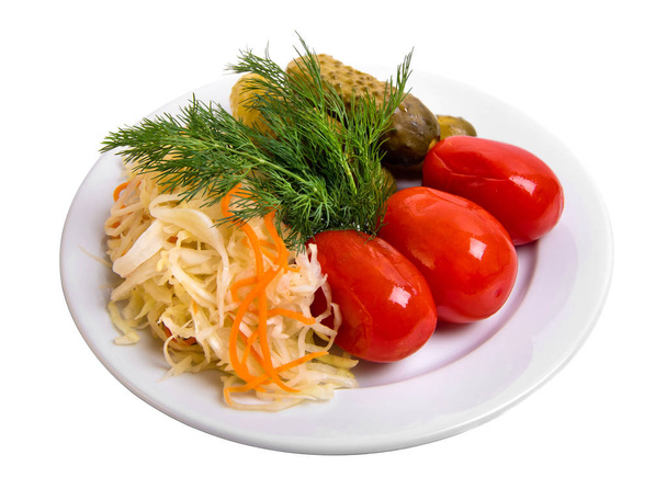 Tomates em conserva e pepinos, chucrute estão no prato, variedade de escabeche isolado em branco
.  - Foto, Imagem