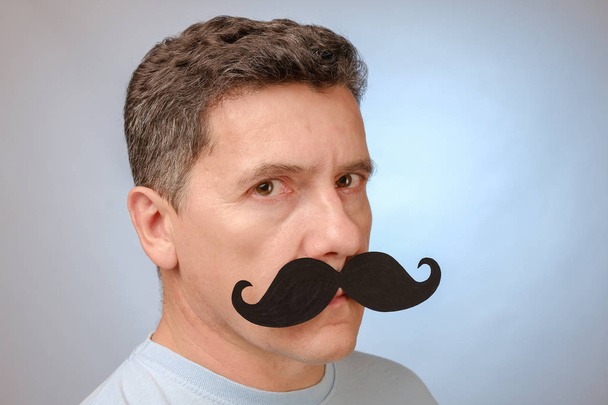 Portrait of a man with a fake mustache to attend an event in November to help men awareness health problems. - Photo, Image