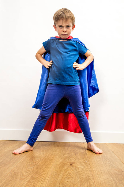 furious superhero child standing, claiming empowerment with strong body language - Фото, изображение