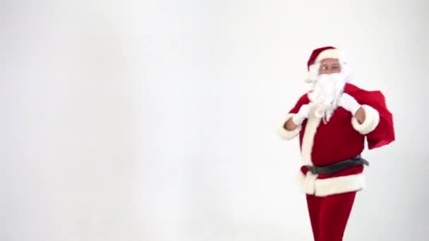 Christmas. Santa Claus on a white background takes out a red box with a bow from a bag, gives it. Present. Surprise. - Footage, Video
