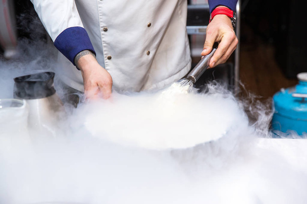 Chef está cocinando helado con nitrógeno líquido
 - Foto, imagen