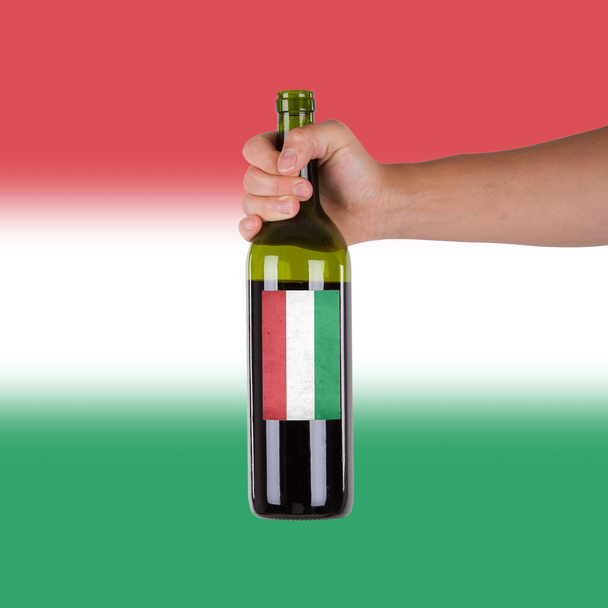 hand holding een fles rode wijn - Foto, afbeelding
