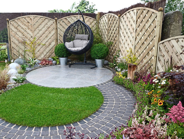 Un jardín urbano basado en curvas que fluyen alrededor de un patio y asiento colgante
 - Foto, Imagen