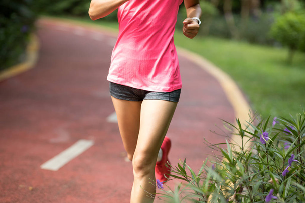 Corredor femenina de fitness saludable corriendo al aire libre en el parque
. - Foto, Imagen