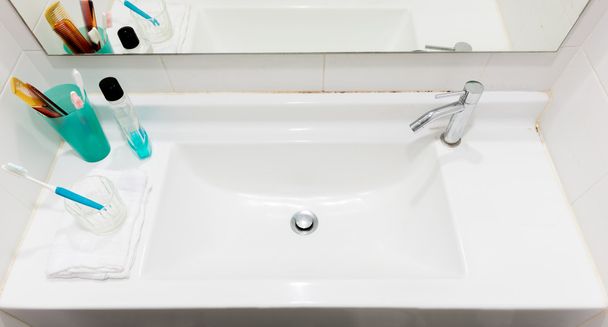 umywalka ze szczoteczka do zębów i szkła i grzebień i płyn do płukania gardła i ręczniki - Zdjęcie, obraz