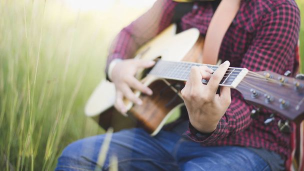 Music in nature, People playing guitar in lawn, Close-up - Photo, Image