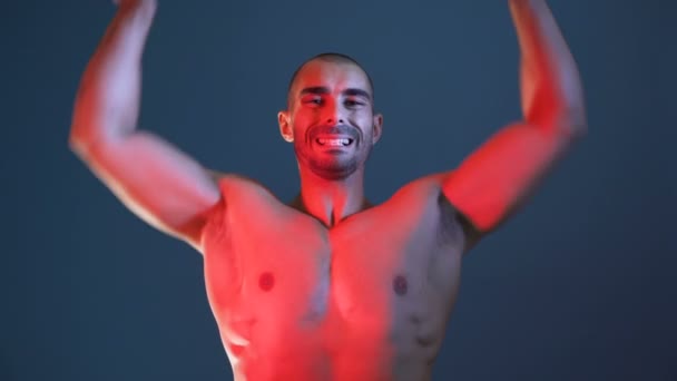 男性のフィットネスモデルは、筋肉の腕を示す,胸と肩,写真セッションのポーズ - 映像、動画