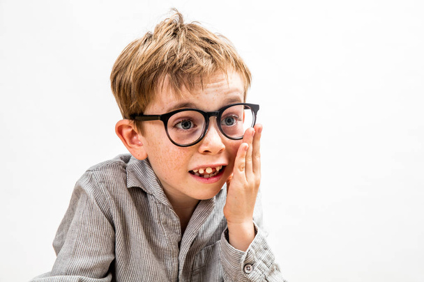 toothless boy touching his oversized eyeglasses for fun genius symbol - Foto, Imagen