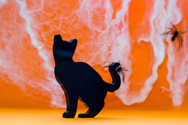 Cadılar Bayramı sagoma gatto nero su fondo arancione con tela ragni  - Fotoğraf, Görsel