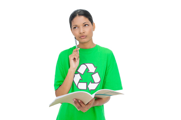 Thoughtful model wearing recycling tshirt holding notebook - Foto, Bild