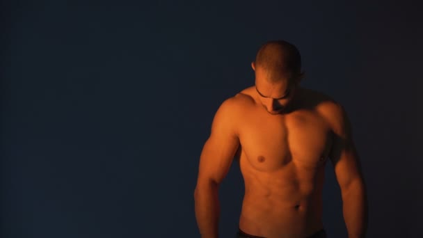 Bodybuilder lässt Muskeln spielen und posiert für Studioaufnahmen - Filmmaterial, Video