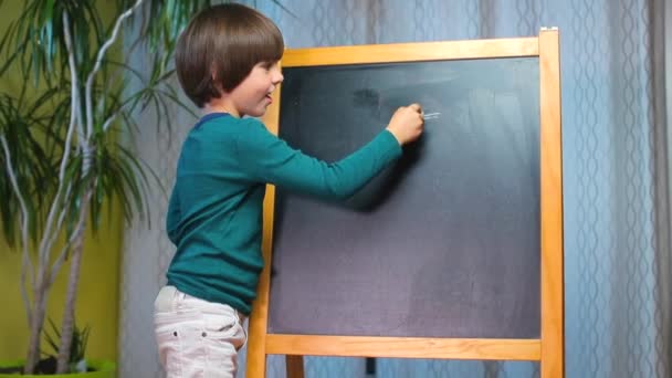 child draws with chalk a euro sign on a blackboard at school. - Кадри, відео