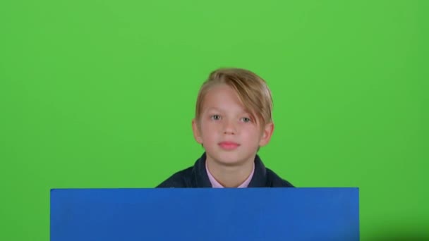 Child boy appeared from behind a blue poster grins curves of faces and hidden again. Green screen - Filmagem, Vídeo