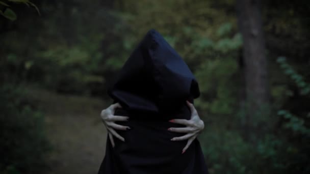 woman in a cloak with a hood embraces herself - Footage, Video