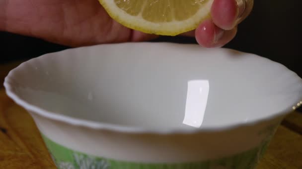 Hand knijp citroen en knijp citroensap in een kom - Video