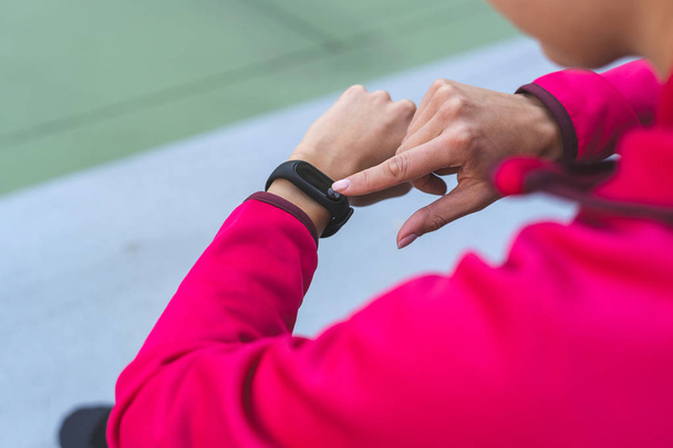 Молодая спортивная женщина, используя умные часы и уйти в отставку после тренировки
 - Фото, изображение