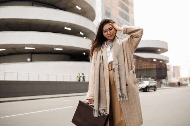Beautiful businesswoman of Asian appearance suffers from headaches on the way to work - Foto, afbeelding