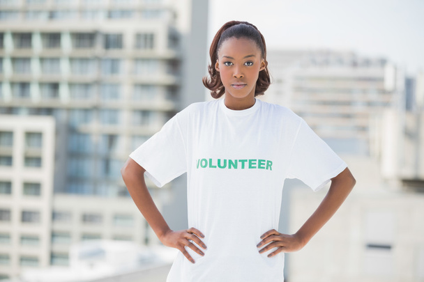 Serious woman with hands on hips wearing volunteer tshirt - Foto, immagini