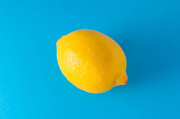 one lemon on a blue background - Fotoğraf, Görsel