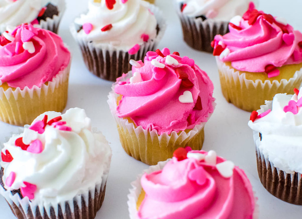 rosa und weiße Zuckerguss Creme Cupcakes mit Herz Streusel - Foto, Bild