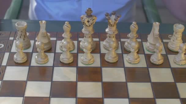 Alter Mann eröffnet die Schachpartie mit weißen Bauern auf e4 - Filmmaterial, Video