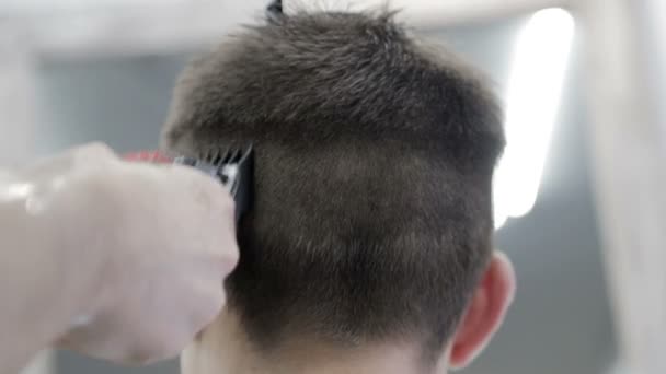 Corte de pelo para hombre en la barbería. Primer plano de un maestro cortando a un hombre de pelo negro con un cortador
. - Metraje, vídeo