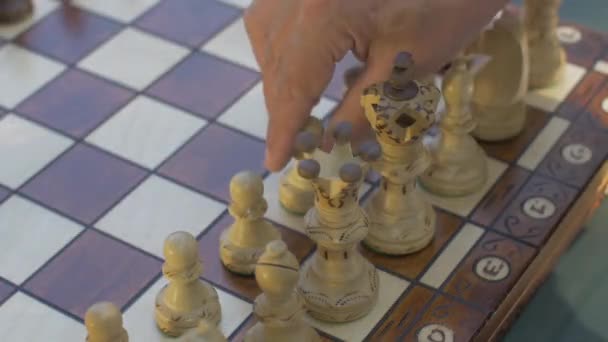 Starý muž otevře šachovou hru s bílým pěšcem na E4 - Záběry, video
