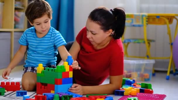 mother playing colorful plastic blocks toy with her son, concept for mother and son playing together. - Footage, Video