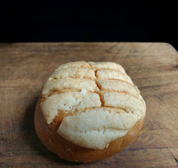 Lähikuva käsintehty kuori leipää puulaudalla musta tausta. tyypillinen meksikolainen leipä
 - Valokuva, kuva